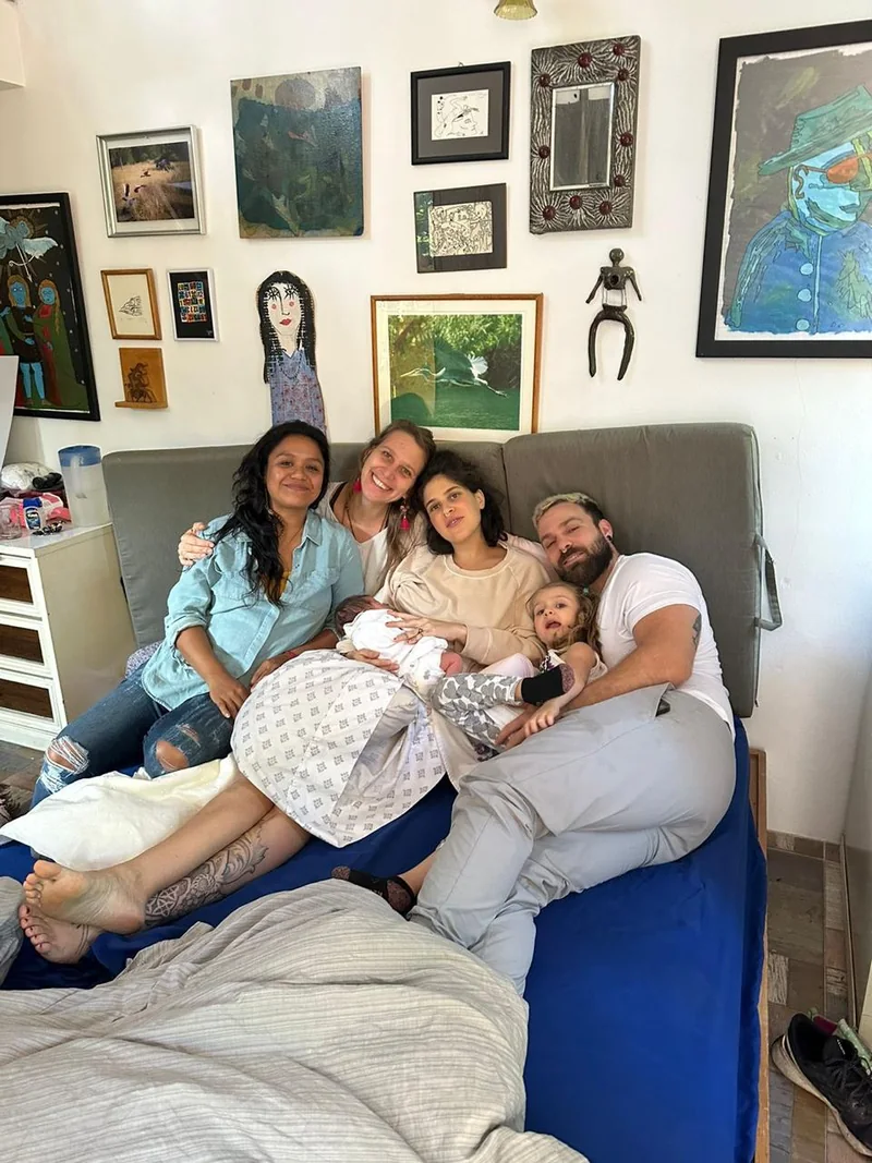Eine Familie und ihre Begleiterinnen im Wochenbett