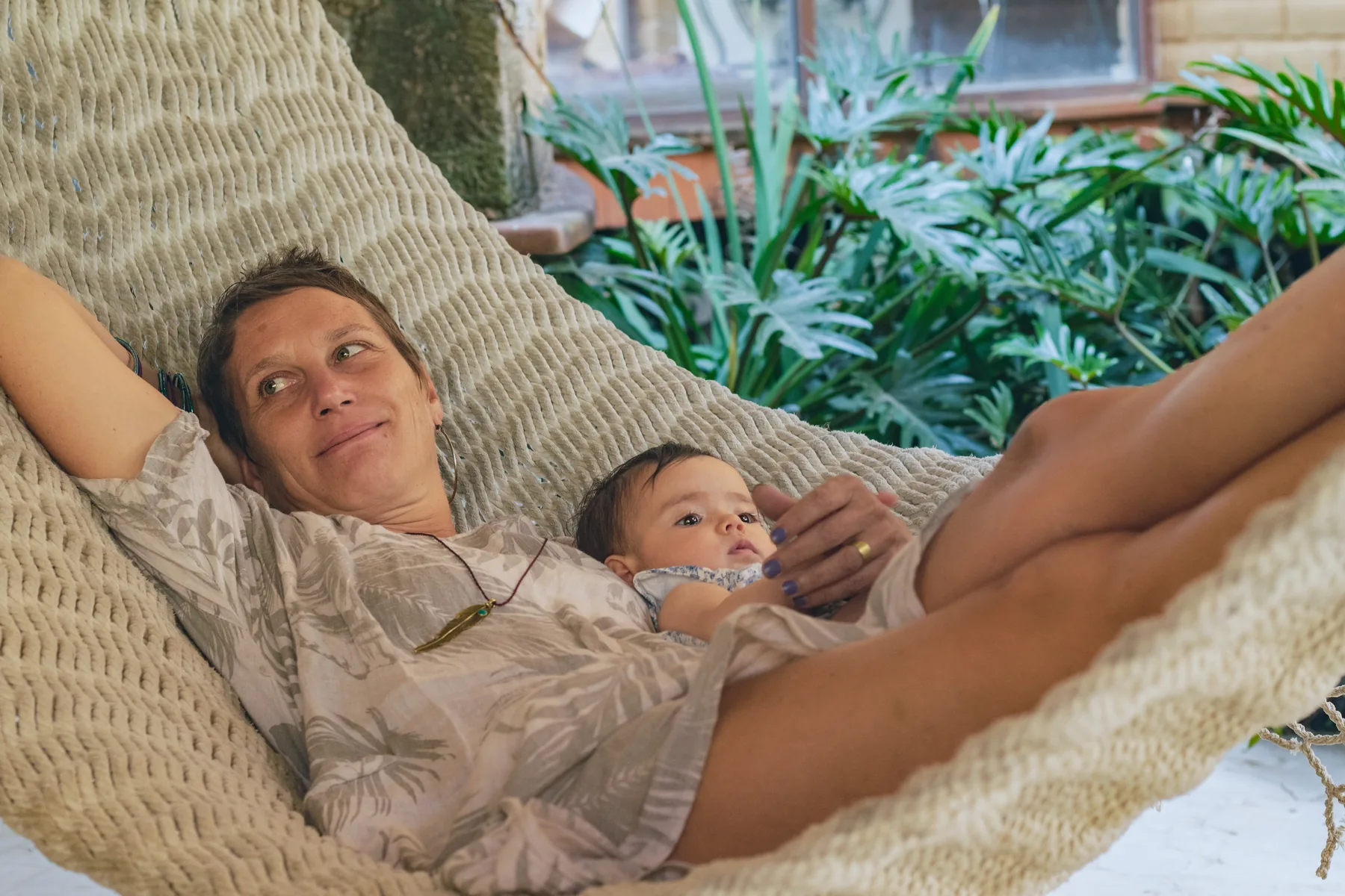 Eine Mutter ruht mit ihrem Baby in einer Hängematte